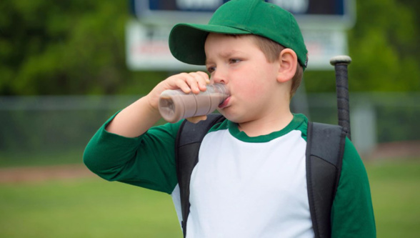 Un jeune baseballeur boit du lait au chocolat Un jeune baseballeur boit du lait au chocolat