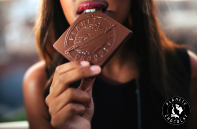 Femme qui croque dans un carré Planète Chocolat© Femme qui croque dans un carré Planète Chocolat©